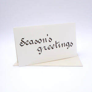 Calligraphy Christmas card with "Season's greetings" written in black. Blank inside. 120mm x 210mm